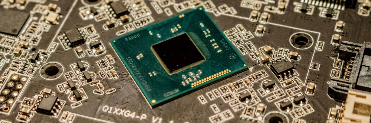 Close-up of a bare processor die mounted on a densely populated circuit board